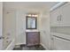 Well-lit bathroom features vanity with storage, bathtub, and white cabinets at 3906 W San Luis St, Tampa, FL 33629