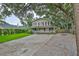 Two-story home with a front porch, concrete driveway, and gravel area at 3906 W San Luis St, Tampa, FL 33629