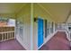 Close up of a charming front porch featuring wood floors, a bright blue door, and exterior sconces at 3906 W San Luis St, Tampa, FL 33629