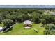 Wide aerial shot of a barn featuring lush green grass, a white fence, and a small decorative airplane nearby at 4312 James L Redman Pkwy, Plant City, FL 33567
