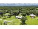 Stunning aerial view of a property featuring a well-maintained lawn, a charming house, and a large barn at 4312 James L Redman Pkwy, Plant City, FL 33567
