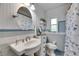 Well-lit bathroom featuring a pedestal sink, toilet, and charming vintage blue and white tile accents at 4312 James L Redman Pkwy, Plant City, FL 33567