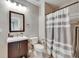 Well-lit bathroom with a single sink vanity and striped shower curtain at 4312 James L Redman Pkwy, Plant City, FL 33567