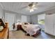Comfortable bedroom with a ceiling fan, natural light, and a cozy bed with a decorative quilt at 4312 James L Redman Pkwy, Plant City, FL 33567