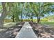 Outdoor ceremony space featuring wooden benches and a walkway beneath a canopy of trees in a serene setting at 4312 James L Redman Pkwy, Plant City, FL 33567