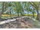 Outdoor ceremony space featuring wooden benches and a walkway beneath a canopy of trees on a sunny day at 4312 James L Redman Pkwy, Plant City, FL 33567