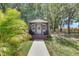 Charming small cabin with brown trim, covered porch, and a concrete walkway amidst a lush green lawn at 4312 James L Redman Pkwy, Plant City, FL 33567