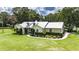 Charming one-story home showcasing dormer windows, a metal roof, beautiful landscaping, and a well-maintained lawn at 4312 James L Redman Pkwy, Plant City, FL 33567