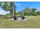 Scenic outdoor fire pit area with Adirondack chairs and gravel base surrounded by lush greenery and trees at 4312 James L Redman Pkwy, Plant City, FL 33567