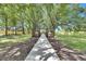 Pathway to a charming wooden structure, surrounded by trees and manicured lawns under a sunny sky at 4312 James L Redman Pkwy, Plant City, FL 33567