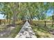 Picturesque pathway leading to a wooden structure, framed by lush greenery and wooden fences at 4312 James L Redman Pkwy, Plant City, FL 33567