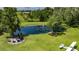 A tranquil pond featuring a fountain, surrounded by a fire pit and lush landscaping, offers a serene outdoor space at 4312 James L Redman Pkwy, Plant City, FL 33567