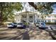 Condo building exterior with covered stairwells and mature trees creating shade for the parked cars at 500 Glennes Ln # 202, Dunedin, FL 34698