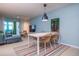 Dining area flowing into a living room, featuring a table with seating for four and a colorful rug at 500 Glennes Ln # 202, Dunedin, FL 34698