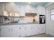 Classic white kitchen with a window above the sink, ample storage, and stainless steel appliances at 500 Glennes Ln # 202, Dunedin, FL 34698