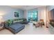 Living room featuring a sectional sofa with tropical print cushions and a view of the florida room at 500 Glennes Ln # 202, Dunedin, FL 34698