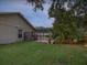 Lush backyard with mature trees, featuring a screened pool visible from the property's side at 5604 Pine Bay Dr, Tampa, FL 33625