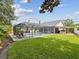 Lush backyard featuring a screened pool and a covered outdoor kitchen and bar area at 5604 Pine Bay Dr, Tampa, FL 33625