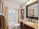 Well-lit bathroom featuring a marble countertop and shower with neutral colored curtain at 5604 Pine Bay Dr, Tampa, FL 33625