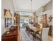 Open dining room with a chandelier, large window, and sliding door access to the outdoor pool area at 5604 Pine Bay Dr, Tampa, FL 33625