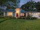 Beautiful single-story home with mature trees, brick accents, and a cozy front porch at dusk at 5604 Pine Bay Dr, Tampa, FL 33625