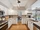 Charming kitchen with white cabinetry, hardwood floors, granite countertops, and stainless steel appliances at 5604 Pine Bay Dr, Tampa, FL 33625