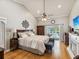Spacious main bedroom with hardwood floors, ceiling fan, and a door leading to the screened in pool and lanai at 5604 Pine Bay Dr, Tampa, FL 33625