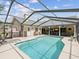 Inviting screened pool area with seating and lush landscaping, perfect for relaxation and entertaining at 5604 Pine Bay Dr, Tampa, FL 33625