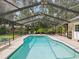 Inviting screened pool area with ample seating and lush landscaping, perfect for relaxation at 5604 Pine Bay Dr, Tampa, FL 33625