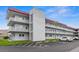 Exterior view of a three story condo building with a red roof and multiple balconies at 5660 80Th N St # B106, St Petersburg, FL 33709