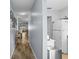 Inviting hallway with wood floors leading to a bright living space and modern kitchen with white appliances at 5660 80Th N St # B106, St Petersburg, FL 33709