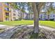 Exterior of multi-story condo building with lush lawn and sidewalk at 5820 N Church Ave # 147, Tampa, FL 33614