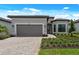 Beautiful single-story home featuring manicured landscaping, brick driveway, and neutral exterior color palette at 6072 Silver Grass Ct, Nokomis, FL 34275