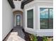 Close up of front entry featuring brick pavers, transom window, and flower beds at 6072 Silver Grass Ct, Nokomis, FL 34275