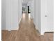 Hallway with wood-look tile floors, white walls, and trim creates a clean, modern feel at 6072 Silver Grass Ct, Nokomis, FL 34275