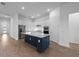Bright, open kitchen featuring an island with seating, stainless steel appliances, and wood floors at 6072 Silver Grass Ct, Nokomis, FL 34275