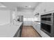 Well-lit kitchen featuring a large island, stainless steel appliances, and light wood-look flooring at 6072 Silver Grass Ct, Nokomis, FL 34275