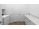 Laundry room features white cabinets, a sink, and a modern washer and dryer at 6072 Silver Grass Ct, Nokomis, FL 34275