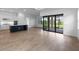 A bright living space features a modern kitchen, tile flooring, and sliding glass doors to the outdoor patio at 6072 Silver Grass Ct, Nokomis, FL 34275