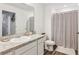 Neutral bathroom features sink with granite countertop, white cabinets, decorative mirror and shower with curtain at 6235 Bucket Ct, Gibsonton, FL 33534