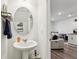 Powder room featuring a pedestal sink, round mirror and decorative shelves. View through doorway to Gathering room at 6235 Bucket Ct, Gibsonton, FL 33534