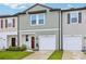 Charming townhome with a red front door, garage, and well-manicured lawn, perfect for Gathering living at 6235 Bucket Ct, Gibsonton, FL 33534
