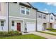 A beautiful townhome with a charming red door, garage, and pristine landscaping, ready for new owners at 6235 Bucket Ct, Gibsonton, FL 33534