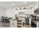 Modern kitchen features a mobile island and a dining table with four chairs in an open floor plan at 6235 Bucket Ct, Gibsonton, FL 33534