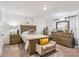 Main bedroom with a queen-size bed, a dresser with a mirror, and a decorative bench with throw pillow at 6235 Bucket Ct, Gibsonton, FL 33534