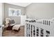 Neutrally painted bedroom with a rocking chair and a white, cow-print themed crib at 6944 80Th N Ave, Pinellas Park, FL 33781