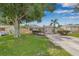 Charming single-story home with a well-manicured lawn, mature trees, and a welcoming light blue front door at 6944 80Th N Ave, Pinellas Park, FL 33781