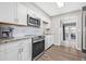 Bright kitchen with white cabinetry, granite countertops, stainless steel appliances, and backyard access at 6944 80Th N Ave, Pinellas Park, FL 33781