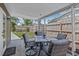 Enjoy outdoor dining on this covered patio with stylish wicker furniture and a tranquil view of the yard at 6944 80Th N Ave, Pinellas Park, FL 33781