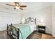 Cozy bedroom with hardwood floors, a ceiling fan, a large window, and a comfortable bed at 701 Poinsettia Rd # 322, Belleair, FL 33756
